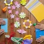 Origami Folding with adult and child hands.
