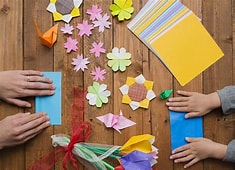 Origami Folding with adult and child hands.